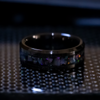 black ceramic ring with pieces of white opals